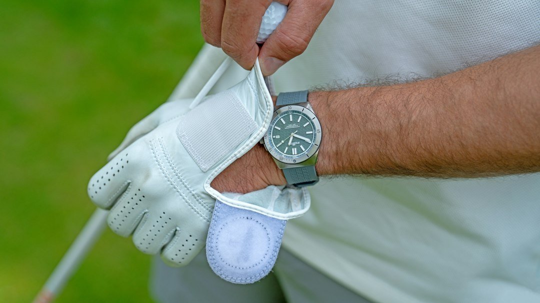 Golfer wearing a glove and holding a club during a weather-ready round.