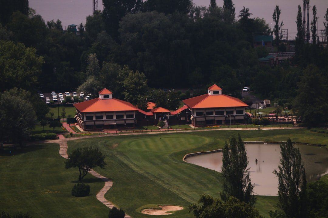 Scenic golf course with clubhouse buildings and a tranquil pond